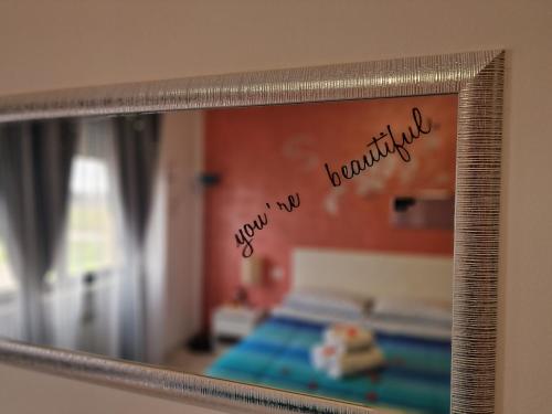 a mirror with the reflection of a bed in a room at Appartamento Divino Tramonto in Altedo