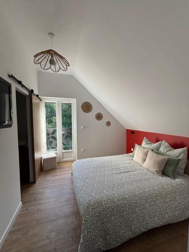 a bedroom with a large bed and a window at La Parenthèse in Régnauville