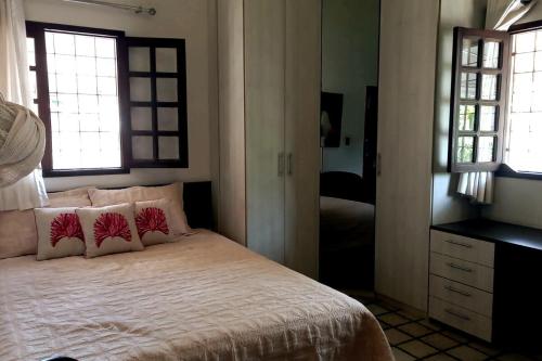 una camera da letto con un letto con due cuscini e uno specchio di Carnaval Olinda-PE, casa à 5km do centro! a Olinda