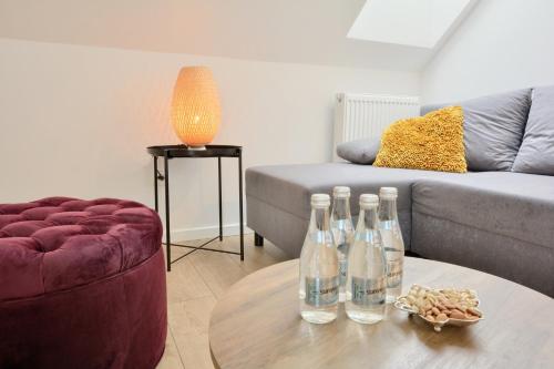 a living room with bottles on a table and a couch at Dworek Polanica in Polanica-Zdrój