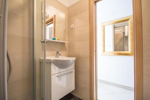 une salle de bain avec un lavabo et un miroir dans l'établissement Apartments Umag Center, seafront with terrace in Umag, à Umag