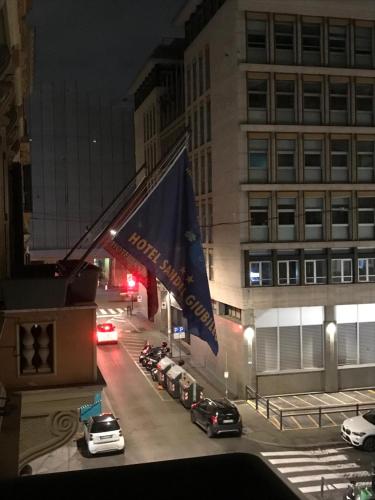 a view of a city street at night with a flag at Sandel Giubileo Hotel in Rome