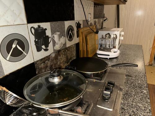 encimera de cocina con fogones y sartén en Enjoy Holidays as its your own place, en Lahore