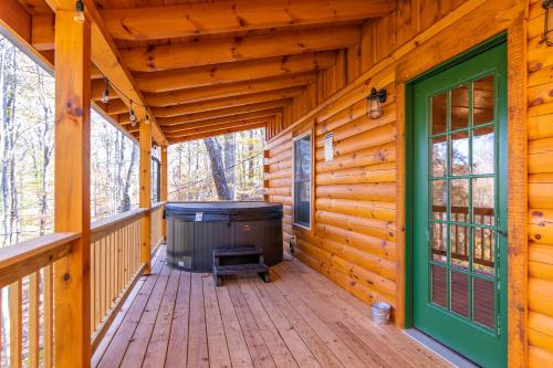 a large deck with a hot tub on a log cabin at Cozy Canopy in Stanton