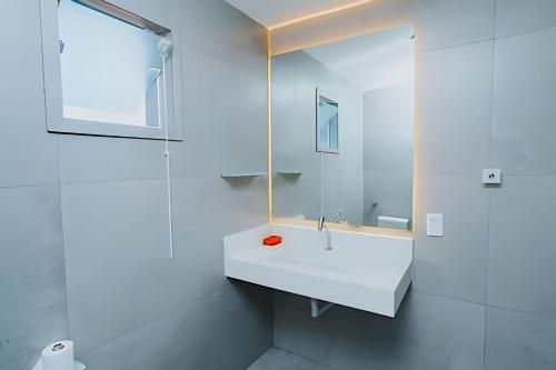 un bagno bianco con lavandino e specchio di Casarão dos Pereira - Acesso a Praia da Figueira ad Angra dos Reis