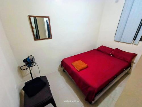a red bed in a white room with a mirror at Departamento entero de 3 dormitorios en urbanización privada con garaje y seguridad 24h in Guayaquil