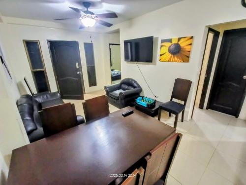 a living room with a table and leather chairs at Departamento entero de 3 dormitorios en urbanización privada con garaje y seguridad 24h in Guayaquil