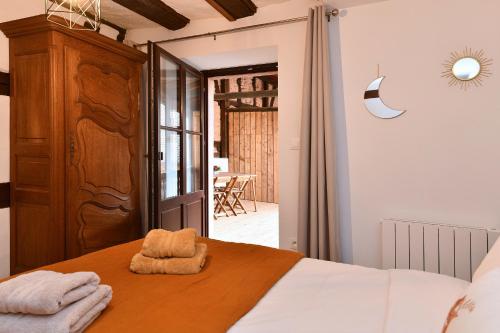 a bedroom with a bed with towels on it at Gîte Entre Vignes et Vergers maison historique in Gueberschwihr