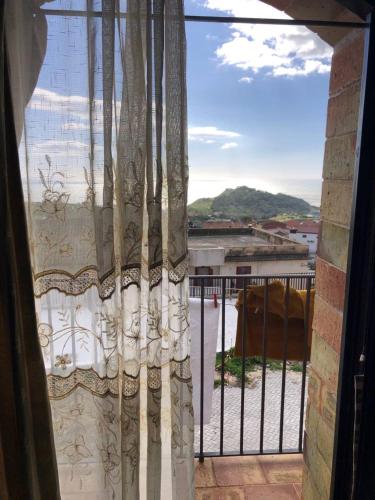 a window with a curtain and a view of a field at Casa vacanza La Guardiola in Realmonte