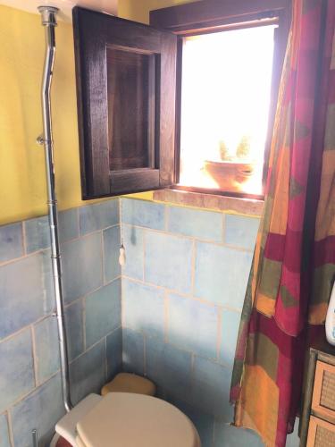 a bathroom with a toilet and a window at Casa vacanza La Guardiola in Realmonte