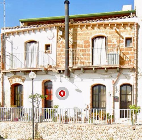 a large white building with a red circle on it at Casa vacanza La Guardiola in Realmonte