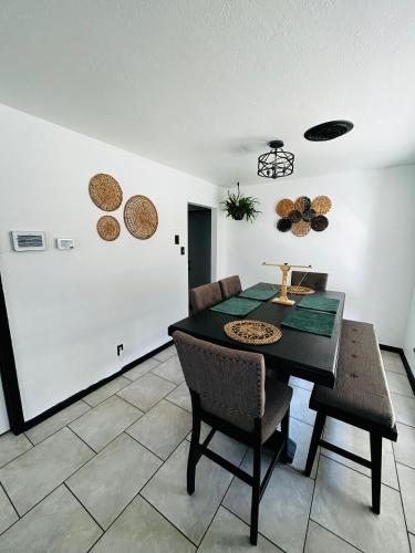 a dining room with a black table and chairs at The Greenhouse Effect in Corpus Christi