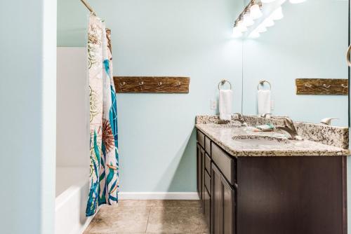 un baño con lavabo y bañera en Boogie Board Bungalow - Pet Friendly PRIVATE POOL, en Port Aransas