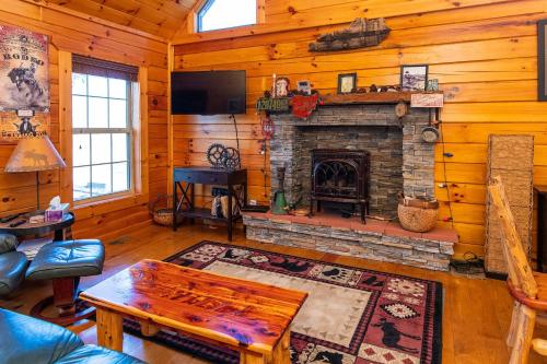 a living room with a fireplace in a log cabin at Climber's Haven in Rogers