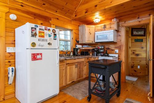 a white refrigerator in a kitchen with wooden walls at Climber's Haven in Rogers