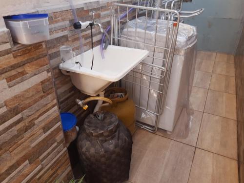 a bathroom with a sink and a trash can at Casa Da Vovó Helena in Vila Velha
