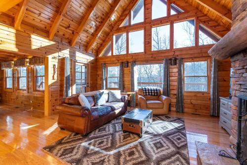 a living room with leather furniture in a log cabin at Mill Creek Point in Rogers