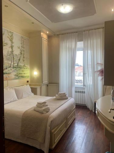a bedroom with a bed with towels on it at Dama Opera Elegantia Rooms in Rome