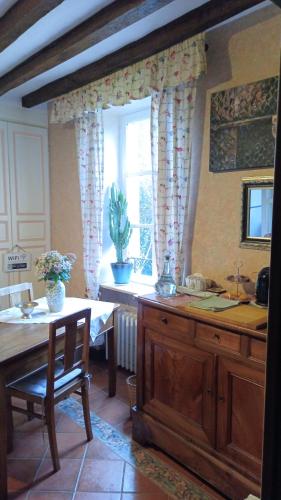 une cuisine avec une table et une table et une fenêtre dans l'établissement Art Cottage, à Pontlevoy