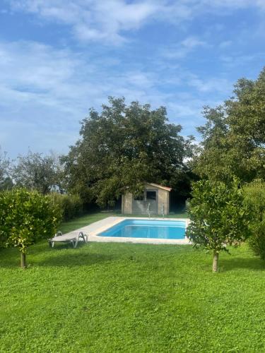 a swimming pool in the middle of a yard with trees at La Casa da Pipa in Cesuras