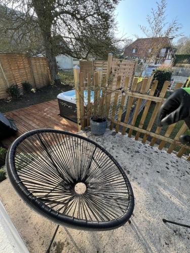 a bicycle wheel sitting on the ground next to a fence at Appartement avec Jacuzzi - Accès Piscine partagée in Criel-sur-Mer