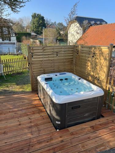 a hot tub sitting on top of a wooden deck at Appartement avec Jacuzzi - Accès Piscine partagée in Criel-sur-Mer