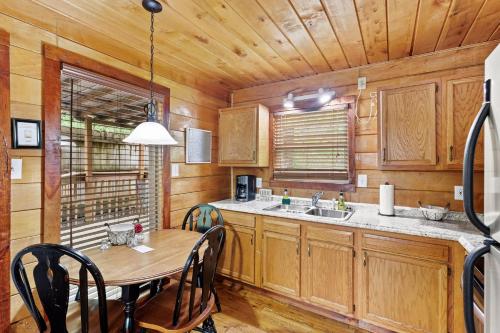 a kitchen with wooden cabinets and a table with chairs at Romantic Hideaway in Rogers