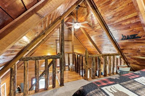 a bedroom in a log cabin with a ceiling fan at Romantic Hideaway in Rogers