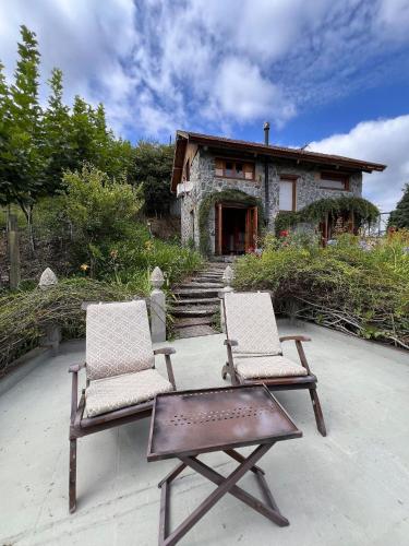 two chairs and a table in front of a house at Pousada Borghetto – Charme e Exclusividade no Vale dos Vinhedos in Bento Gonçalves