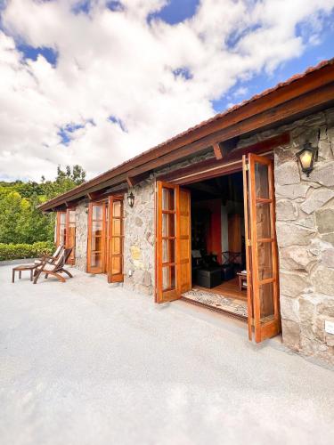a stone house with wooden doors and a patio at Pousada Borghetto – Charme e Exclusividade no Vale dos Vinhedos in Bento Gonçalves