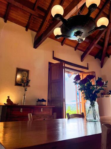a dining room with a table and a bird chandelier at Pousada Borghetto – Charme e Exclusividade no Vale dos Vinhedos in Bento Gonçalves