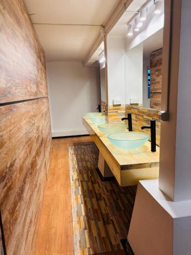 a bathroom with four sinks and a large mirror at NW Hotel Nomada in Osorno