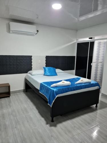 a bedroom with a large bed with blue sheets at Finca Hotel Relax San Jerónimo in San Jerónimo