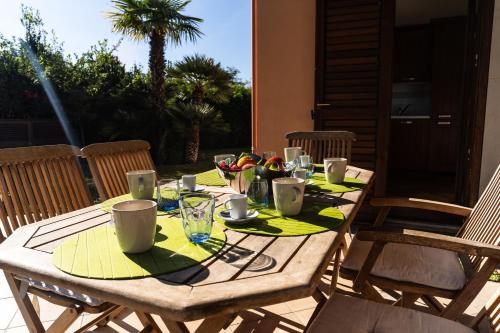 a wooden table with plates and cups on it at Villa Scilla - Pool & Garden in Plaia Grande