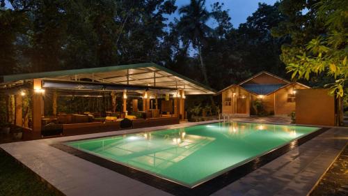a swimming pool in the backyard of a house at Ududola Rainforest Cottages in Migahatenna