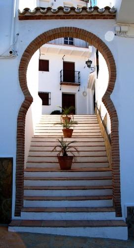an archway with stairs and potted plants in a building at Al Lago in Zahara de la Sierra