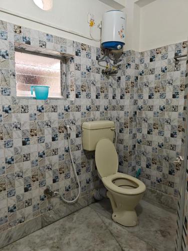 a bathroom with a toilet and a window at 4 Bedroom 3 Bathroom Fully AC Private Flat up to 14 People in Kolkata