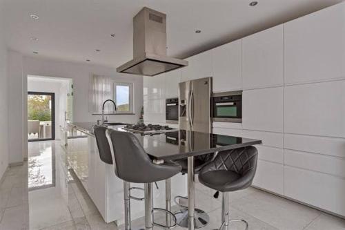 a kitchen with a counter and stools in it at The Beautiful White House in Kortenberg