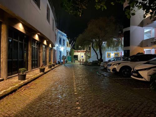 a cobblestone street at night with cars parked at Apartamentos Turisticos Verdemar in Horta
