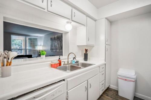 a white kitchen with a sink and a window at Towne Plaza Apartments 104 - 7 km from FIFA Fest in Houston