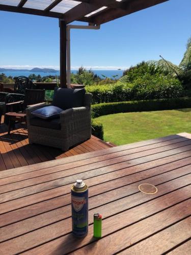 a can of soda sitting on a wooden table on a deck at Kaiteriteri Affordable Luxury Somehing Special in Kaiteriteri