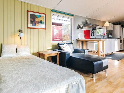 a bedroom with a bed and a couch and a chair at 4 person holiday home in Vordingborg-By Traum in Vordingborg
