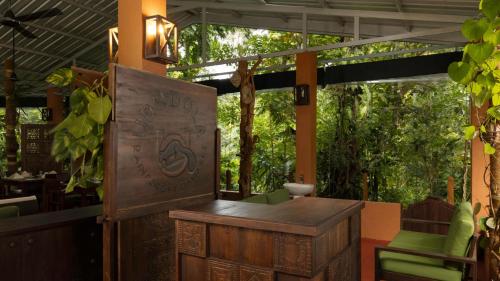 an outdoor bar with a table and chairs on a patio at Ududola Rainforest Cottages in Migahatenna