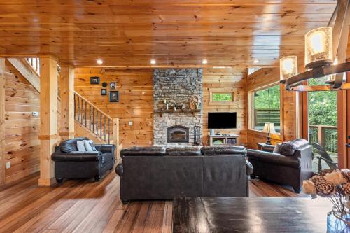 a living room with couches and a stone fireplace at Sky Pointe in Rogers