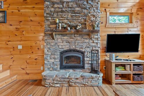 a stone fireplace in a living room with a television at Sky Pointe in Rogers