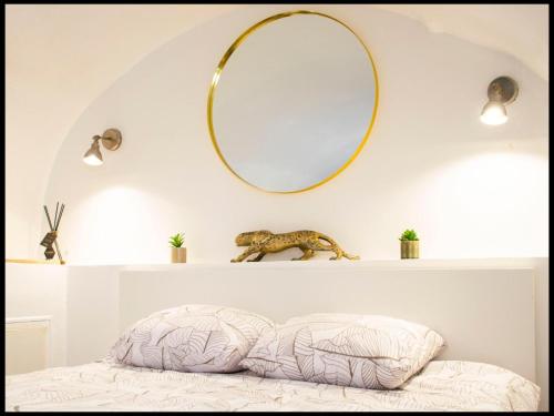 - un miroir sur un mur au-dessus d'un lit avec un oreiller dans l'établissement La Calade Enchantée pour 4, à Marseille