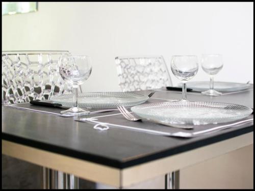 une table avec des assiettes et des verres au-dessus dans l'établissement La Calade Enchantée pour 4, à Marseille