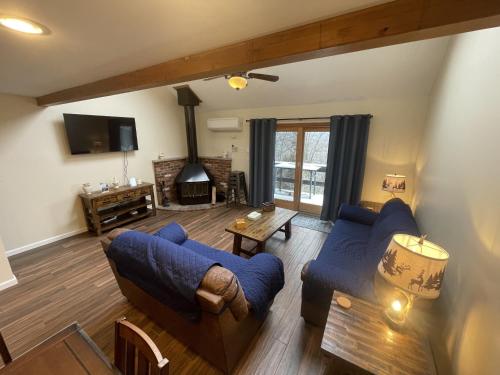 a living room with two blue couches and a fireplace at Mountain Home at Camelback in Tannersville