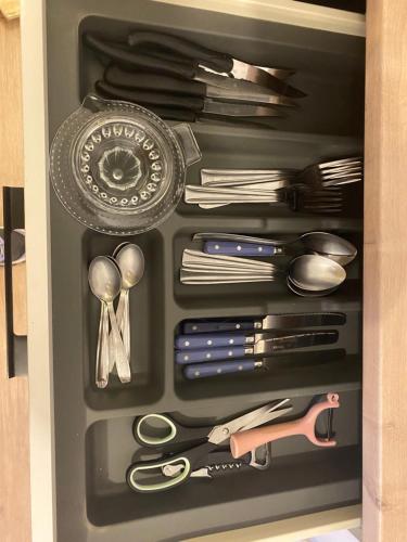 un tiroir rempli d'ustensiles et d'autres articles dans l'établissement Maison lumineuse, à Chef-Boutonne