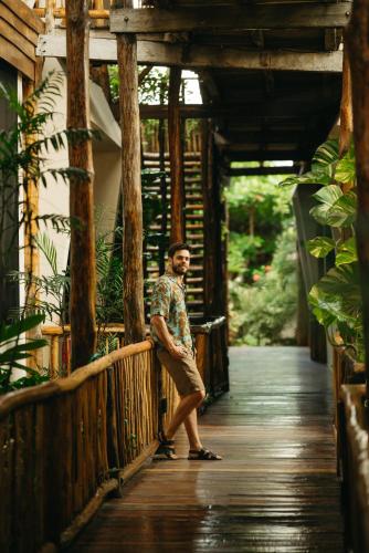 a man is standing on a wooden bridge at Casa Teka in Tulum